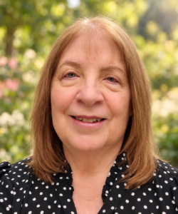 Mary T. Newport, MD, author and physician, smiling against a softly blurred garden background.