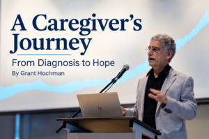 Grant Hochman speaking at a podium beside the title “A Caregiver's Journey: From Diagnosis to Hope,” describing his experience caring for his wife with early-onset Alzheimer's disease.